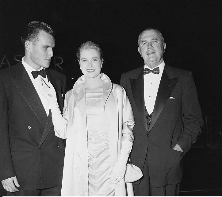 Grace Kelly arrives at the premiere of The Country Girl with her brother Jack Kelly and father John B. Kelly.
